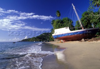 Old wooden fishing boat on sandy beach, Grenada, Caribbean