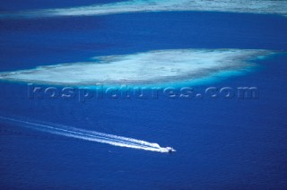 Powerboat speeds passed shallow reef, Polynesia