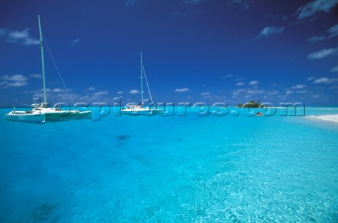Two cruising catamarans anchored in clear shallow water  Seychelles