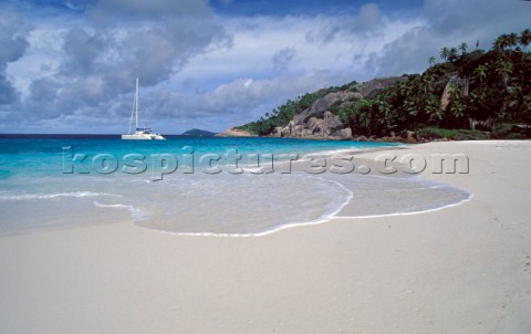 Yacht anchored off idyllic sandy beach  Seychelles