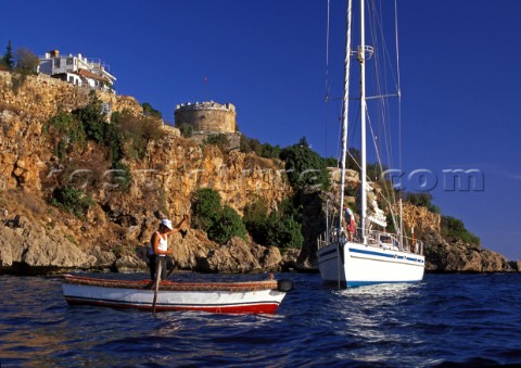 Local fishing boat passed a yacht at anchor  Antalaya Turkey