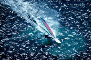 Aerial view of windsurfer speeding through the water