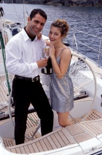 Couple with Champagne on Deck Lifestyle - Charter 99 Romantic couple celebrate a birthday onboard a yacht during a cruising holiday