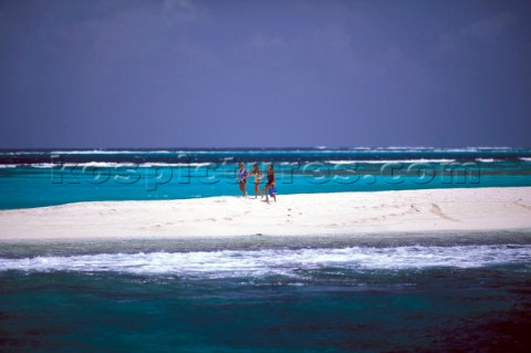 Three girls walking on the beach in the Seychelles Indian Ocean