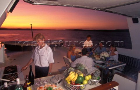 Evening BBQ aboard a superyacht with crew cooking the food