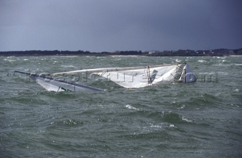 Supported by its bouyancy a J24 yacht sinking under sail after a broach