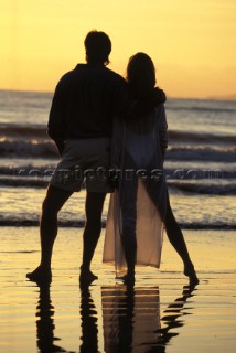 Couple looking ou to sea at sunset