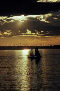 Two sailing yachts sailing at sunset
