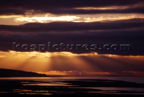 Sun rays behind cloud in the Severn estuary UK
