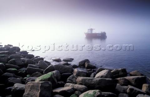 Fishing boat in mist  Kimmeridge Bay Dorset UK