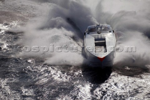 Aerial shot of powerboat crashing through a wave
