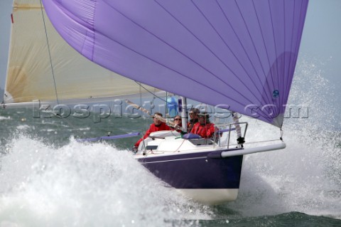 Purple J80 sportsboat Just Savage planing and surfing downwind at 20 knots under asymmetric spinnake