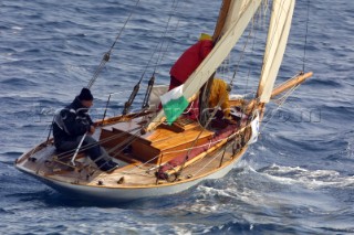 Man at the helm of a small classic sloop