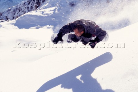 Snowboarder and his shadow mid air