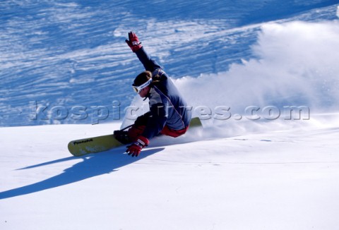 Snowboarder carving through fresh powder snow