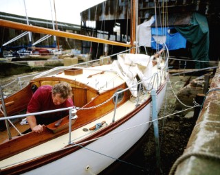 Man restoring classic wooden yacht at traditional boat builders, Littlehampton, Sussex