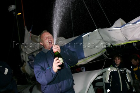 Spraying champagne in celebration British Open 60 sailor Mike Golding of Ecover arriving in Les Sabl