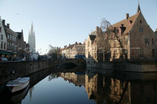 Building of city reflected in canal, Brugge, Belgium