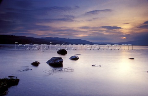 Still water of Loch Lomond at sunset