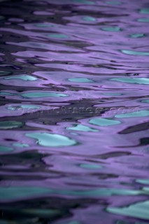 Texture on the water and reflection of a lilac purple and turquoise spinnaker of a sportsboat racing in the Silva J80 World Championships 2005 in Falmouth UK