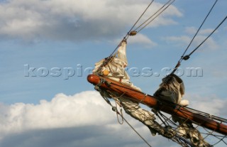 Bowsprit of classic yacht under clouds