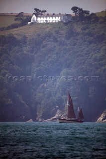 Classic yacht in front of steep coastline
