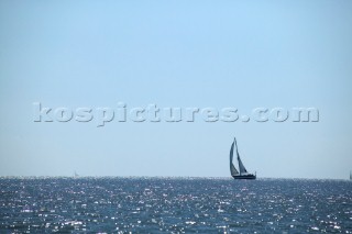 Single yacht sailing on open sea.