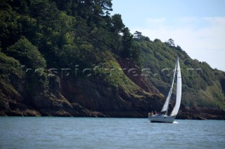 Cruising yacht sailing off the Devon coast.
