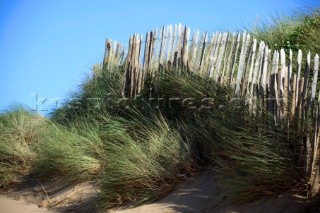 Wooden fence on sand dunes at Bantham beach, Devon