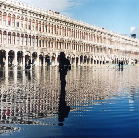 Silhouette of person standing in flooded street in Venice