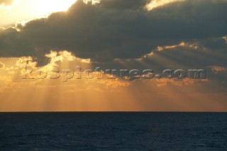 Rays of sun breaking through clouds over seascape