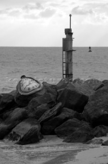 Abract time clocks on the rocks next to a navigation mark in Key West, Florida, USA. Key West