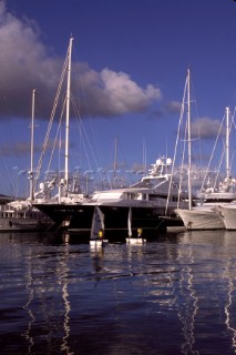 Optimists and superyachts in marina port