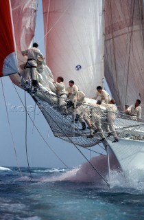 The crew in teamwork to lower the sails on the bowsprit of the schooner sailing superyacht Adela