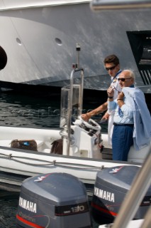 Professional crew man takes guest and owner to his superyacht on a rib tender
