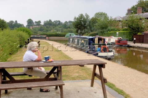 Woman watching narrow boats on the Llangollen canal at EllesmereShropshireUK
