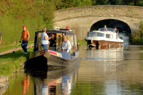 People on cruser passing  under bridge 18 and waiting behind a narrow boat to enter the lock below a