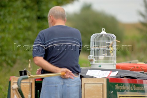 Man with canary in cage on narrow boat on the Llangollen canal at BettisfieldClwydWalesSeptember 200