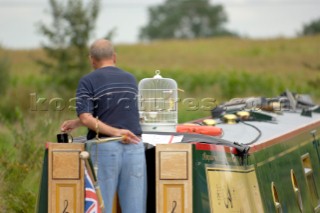Man with canary in cage on narrow boat on the Llangollen canal at Bettisfield,Clwyd,Wales,September 2006.