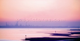 A pink sunset over an industrial skyline