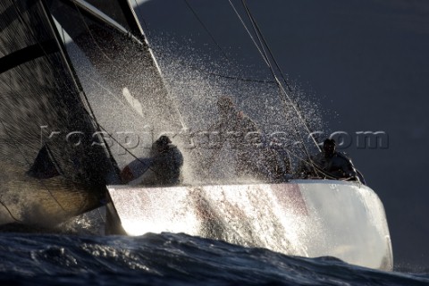 Silhouette of AC yacht in spray and rough water