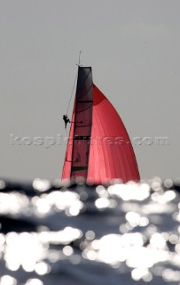 Red spinnaker and bowman behind wave