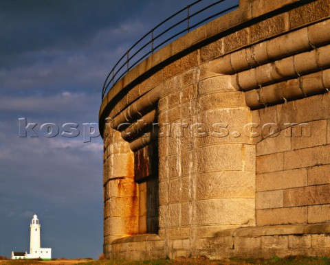 Warm sunlight on the Cornish granite walls of Hurst castle in Hampshire with Hurst High lighthouse i