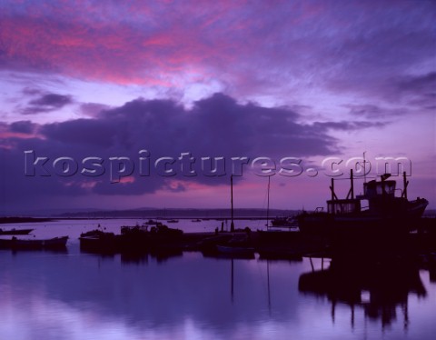 A vibrant dawn sky produces purple hues in the water The Hurst castle ferry is on the slipway at Key