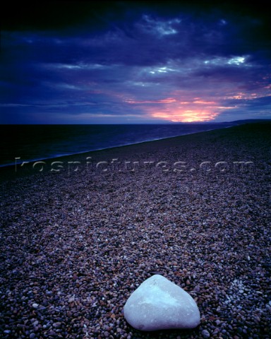 Chesil Beach in Dorset Last rays of sun break through heavy cloud in an act of defiance Large triang