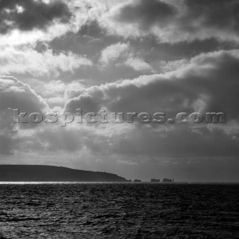 Strong SW wind bringing changeable conditions Needles rocks and Isle of Wight silhouetted with band 