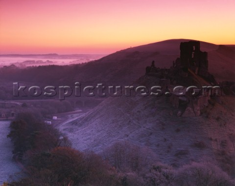 A harsh frost before dawn at Corfe in Dorset with mist on the plain near Poole Harbour The Castle ru