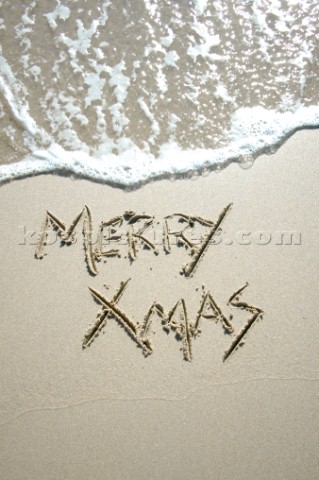 Merry Christmas Xmas sign writing message on a sandy beach in Tarifa Spain near Gibraltar