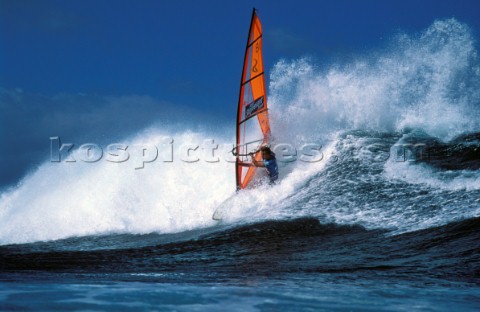 Windsurfer in big crashing wave