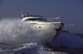 A Fairline powerboat speeds through the water leaving trail of spray